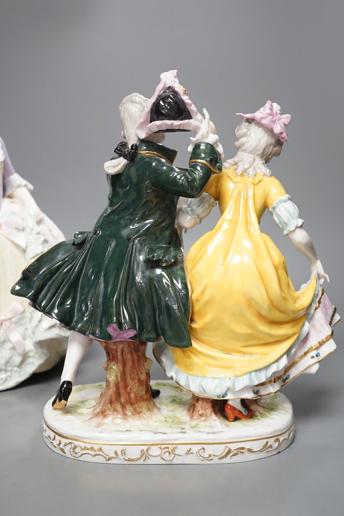 An Italian porcelain group of a dancing couple, 31cm, and an Italian maiolica figure of a lady